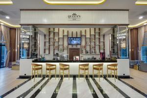 a hotel lobby with a bar with stools at Aydinbey Queen’s Palace & SPA in Belek