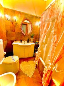 a bathroom with a sink and a toilet and a mirror at Odysseas ART Villa in Póros Kefalonias