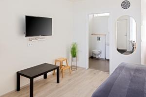 a living room with a bed and a tv on a wall at South Central Apartments in Brautarholt