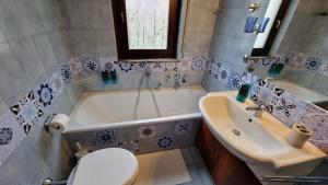 a bathroom with a tub and a toilet and a sink at Casa Lord Malonno in Malonno