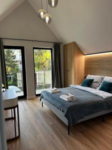 sypialnia z łóżkiem, biurkiem i oknami w obiekcie Apartamenty Piasek i Słońce w Jastrzębiej Górze