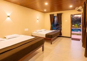a hotel room with two beds and a window at Areca Jungle Stays by StayApart in Potolai