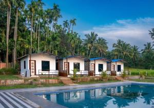 a resort with a pool in front of it at Areca Jungle Stays by StayApart in Potolai