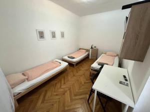 two beds in a room with a wooden floor at Apartment Vlhka in Brno