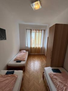 Cette chambre comprend 3 lits et une fenêtre. dans l'établissement Apartment Vlhka, à Brno