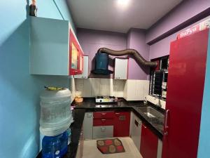 eine Küche mit einer Flasche Wasser und einem Kühlschrank in der Unterkunft Avena 2BHK Fully Furnished Flat Mid Of City Siliguri in Shiliguri