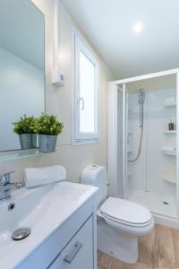 a white bathroom with a toilet and a shower at Mobile Homes Rapoća in Nerezine