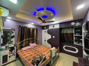 Schlafzimmer mit einem Bett und einer Decke mit blauem Licht in der Unterkunft Avena 2BHK Fully Furnished Flat Mid Of City Siliguri in Shiliguri