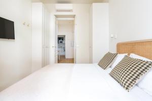 1 dormitorio con 1 cama blanca y 2 almohadas en Charming Apt Sevilla Center by the bullring by Rodo street, en Sevilla