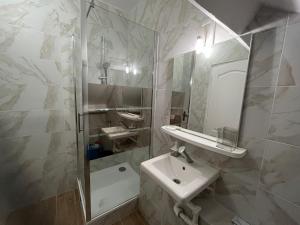 y baño blanco con lavabo y ducha. en Appartements proches CDG Le Bourget dans maison francilienne typique, en Le Blanc-Mesnil