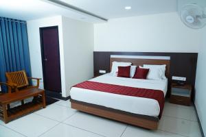 1 dormitorio con 1 cama grande y 1 silla en Rainbow Inn, en Munnar