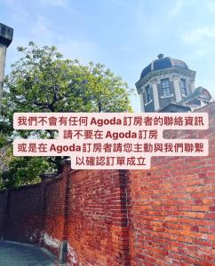 a brick wall with a street sign in front of a building at Happy Hotel in Lugang