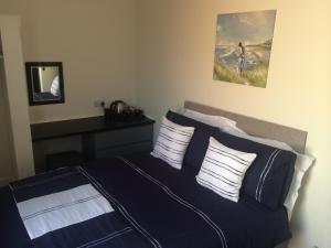 a bedroom with a blue and white bed with pillows at The Prince Guest House in Great Yarmouth