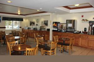 a restaurant with wooden tables and chairs and a bar at Yellowstone Lodge in West Yellowstone