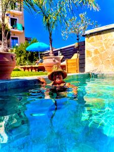a person wearing a hat in a swimming pool at Odysseas ART Villa in Poros
