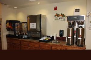 a kitchen with a counter with a coffee maker and a refrigerator at Yellowstone Lodge in West Yellowstone