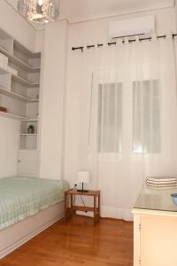 een slaapkamer met een bed en een tafel met een lamp bij Ellis house in Agrinion
