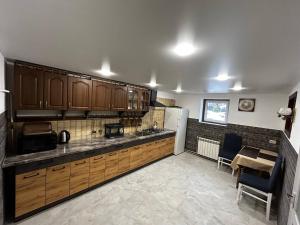 a kitchen with wooden cabinets and a table in it at Зоряні Карпати in Slavske