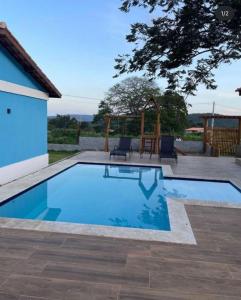 - une piscine avec une table et une balançoire dans l'établissement Village em Itaitu, à Itaitu