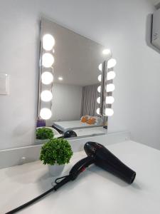 a black hair dryer on a counter in front of a mirror at Arte Cheras Duplex Near MRT 1 in Kuala Lumpur