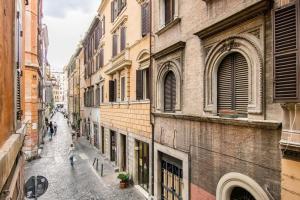 una persona che cammina lungo una strada tra gli edifici di Pop House a Roma