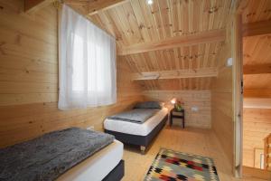 two beds in a wooden room with a window at Torfu Sianożęty in Sianozety