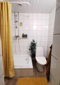 y baño con bañera, aseo y ducha. en Retro Apartment in Kiviõli, en Kiviõli