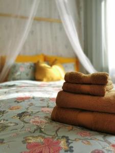 una pila de toallas sentadas encima de una cama en Retro Apartment in Kiviõli, en Kiviõli