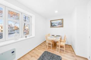 a dining room with a table and chairs and windows at Apartmán Barula in Kašperské Hory