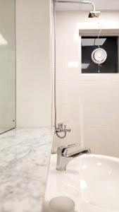 uma casa de banho branca com um lavatório e um espelho em WeStay Ladies Hostel em Dubai