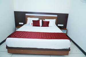 a bedroom with a large bed with red pillows at Rainbow Inn in Munnar