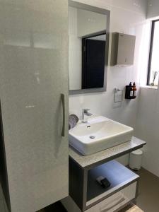 a bathroom with a white sink and a mirror at The Raz in Harrismith
