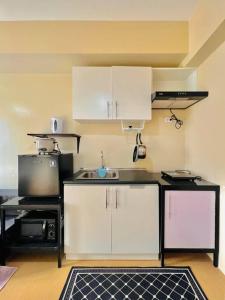 eine Küche mit weißen Schränken und einer schwarzen Arbeitsplatte in der Unterkunft A2* * Uptown Retreat in Iloilo City
