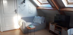um pequeno quarto com um sofá e uma televisão em Eendrachtweg 4 em De Cocksdorp