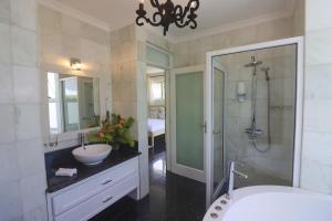 a bathroom with a shower and a sink and a tub at Chateau Elysium - Two bedroom villa 2 in Beau Vallon