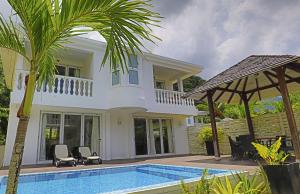 a villa with a swimming pool and a house at Chateau Elysium - Two bedroom villa 2 in Beau Vallon