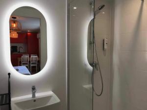 a bathroom with a shower with a sink and a mirror at Cit'hotel Design Booking Evry Saint-Germain-lès-Corbeil Sénart in Saint-Germain-lès-Corbeil