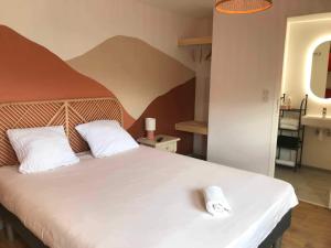 a bedroom with a large bed with two white pillows at Cit'hotel Design Booking Evry Saint-Germain-lès-Corbeil Sénart in Saint-Germain-lès-Corbeil