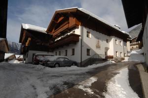 budynek z samochodem zaparkowanym na śniegu w obiekcie Naflerhof w mieście Obertilliach