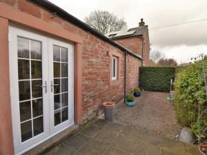 a brick house with a door and a courtyard at 1 bed property in Langwathby Cumbria SZ113 in Langwathby