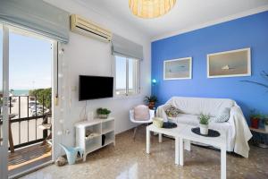 a blue living room with a couch and a tv at Apartamento La Barca - Chipiona in Chipiona