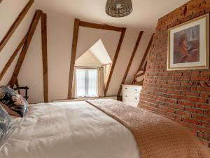 um quarto com uma parede de tijolos e uma cama em 2 Bed in Tattingstone 86982 em Bentley
