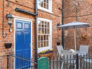 a blue door and a table with an umbrella at 2 bed property in Horncastle 86663 in Horncastle