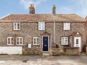 a brick house with a blue door at 2 Bed in Bacton 86430 in Bacton