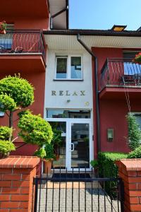 un edificio rojo con un letrero que dice relájate en Dom Gościnny Relax, en Rewal