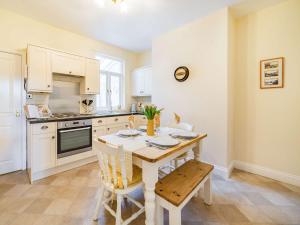 a kitchen with a table and chairs in a room at 2 Bed in Newby Bridge 87621 in Newby Bridge