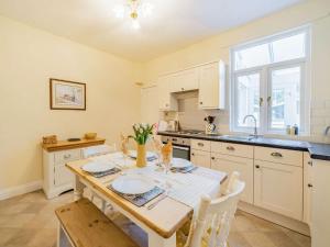 a kitchen with a table with chairs and a sink at 2 Bed in Newby Bridge 87621 in Newby Bridge
