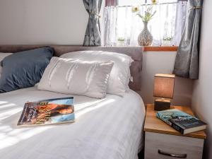 a bedroom with a white bed with a book on it at 1 bed in Brynteg 87362 in Llanwenog