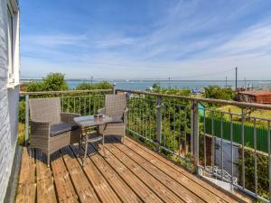 a wooden deck with two chairs and a table on it at 4 Bed in East Cowes 88655 in East Cowes