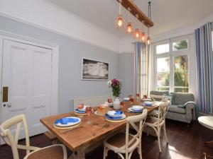a dining room with a wooden table and chairs at 4 Bed in East Cowes 88655 in East Cowes
